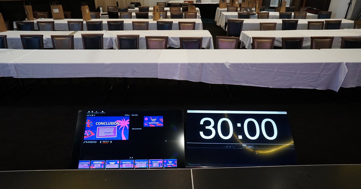 Confidence monitors at stage level showing the next slide and a 30 minute countdown