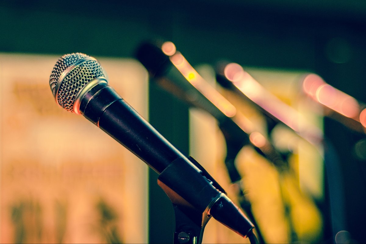 Handheld microphone on a stand in front of a stage