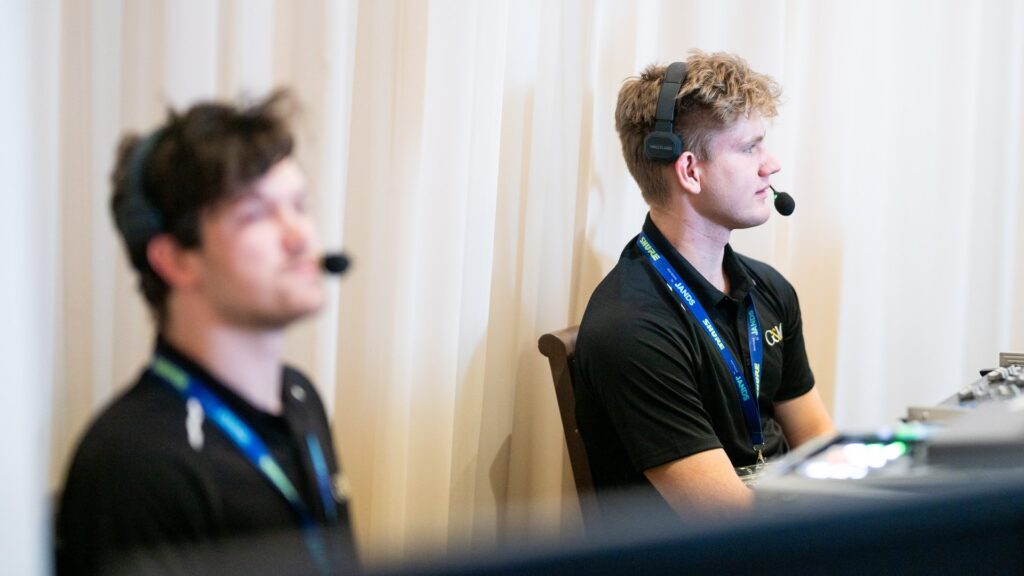 Two technicians with headsets working at the production desk