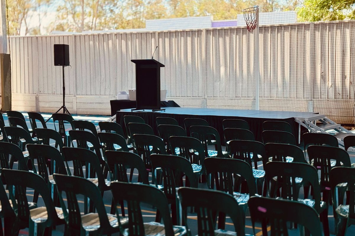 Skirted stage deck with lectern and speaker set up for a graduation and awards event at Griffith University Logan