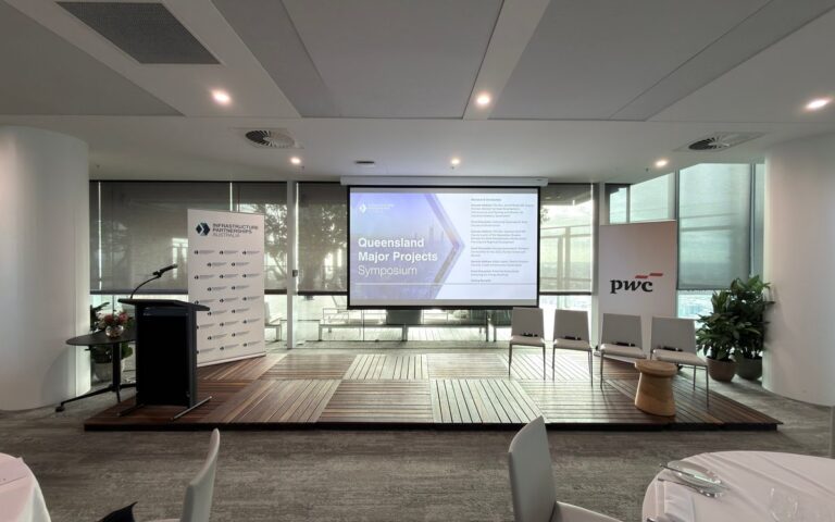 Symposium stage with a projection screen, lectern and stage deck
