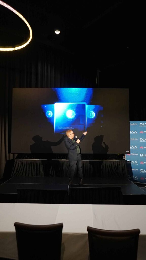 Presenter speaking on stage in front of a large LED wall